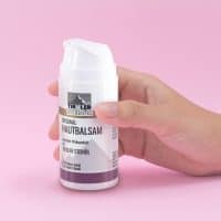 Tiroler Steinöl Hautbalsam in einer Hand